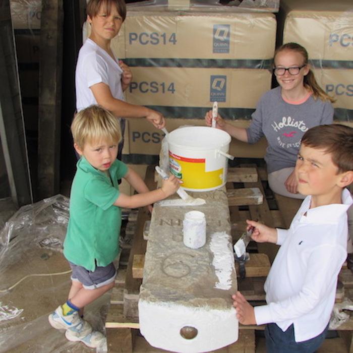 Holme-next-the-Sea children helping to paint the milestone