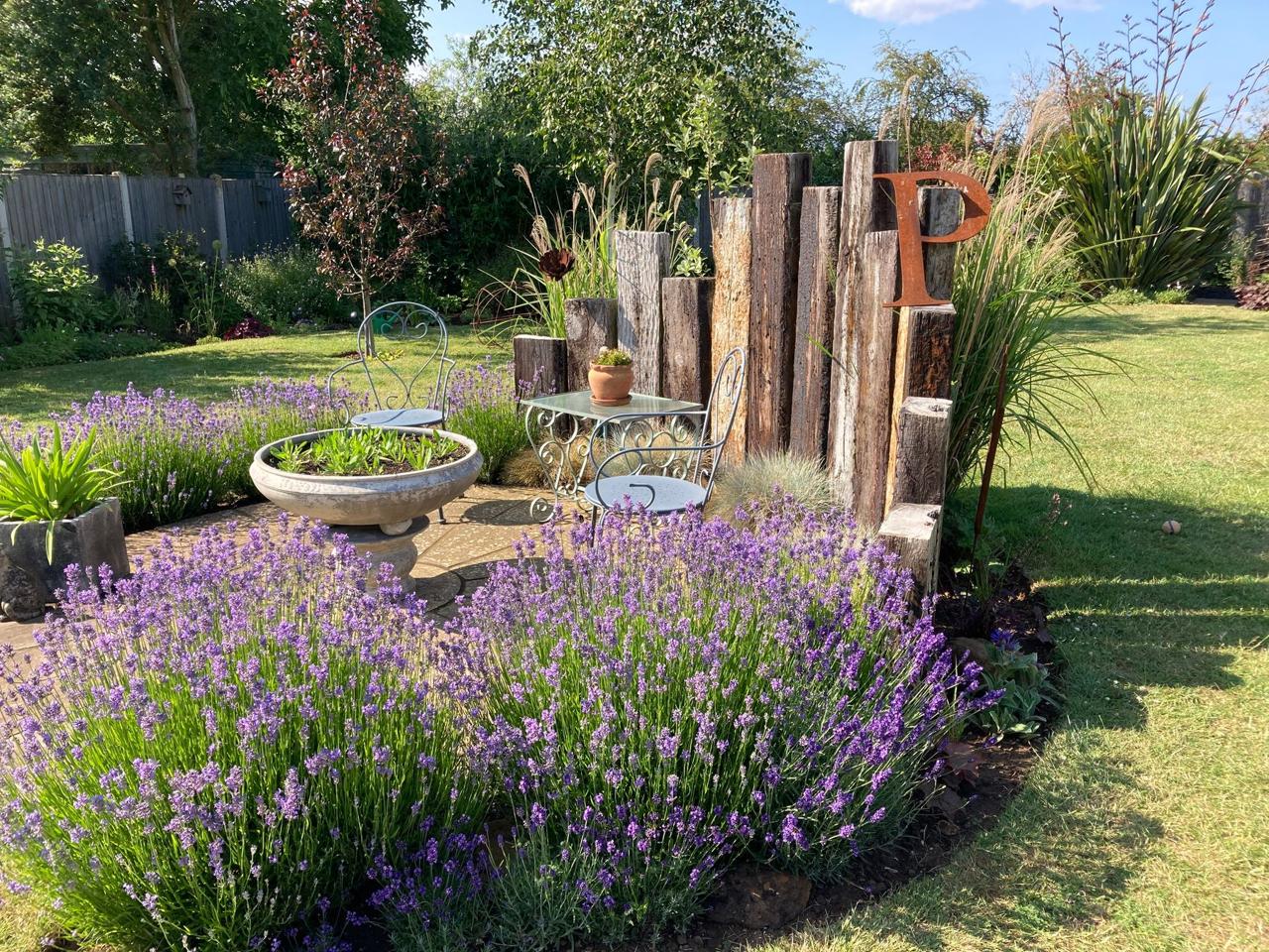 Lavender and grasses around a seating corner with reclaimed timber posts