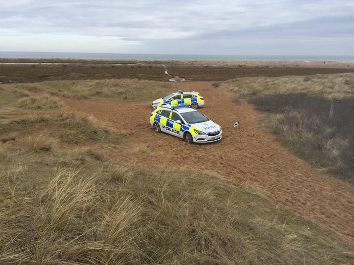 Police vehicles stuck on the beach