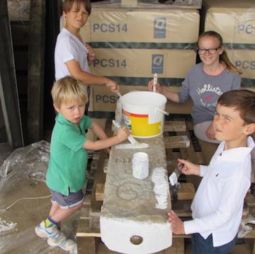 Holme-next-the-Sea children helping to paint the milestone