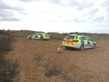 Police vehicles stuck on the beach