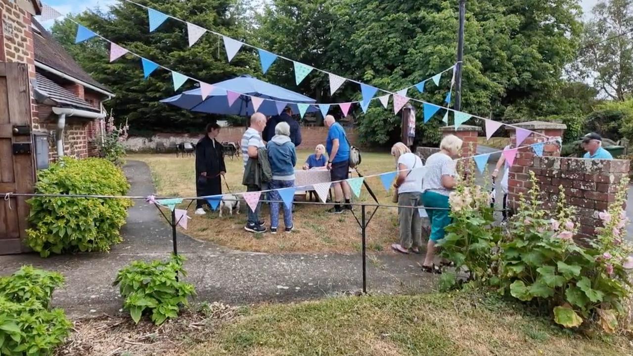 Visitors gathered under bunting at the entrance to one of the gardens